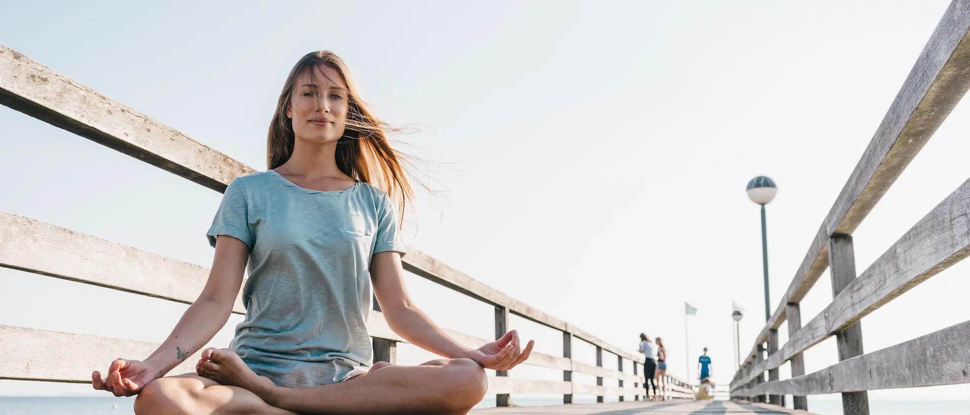 Woman meditating on the pier